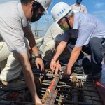 新業建設名譽董事長穆椿松先生（圖前排右一），於樓頂安裝「噴金漆鋼筋」即為上樑，古有云「上樑有如人之加冠」，不論在建築進度及民俗學上都極具意義。