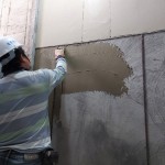 除了事先調和抿石子，先於泥作打底面上抹上一層黏著劑，使抿石子與牆面緊密貼合。