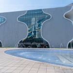 臺中國家歌劇院由日本建築大師『伊東豊雄』設計，透過「曲牆工法」的設計概念構成，整棟建築零直角、無樑無柱，是世界獨一無二的涵洞建築。