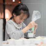 小小雙手緊握擠花袋，細心為杯子蛋糕擠上糖霜，手作成了最甜的學習，悄悄留下屬於成長與節日的美好回憶。